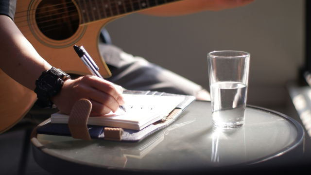 songwriting_notebook_pen_guitar_unsplash