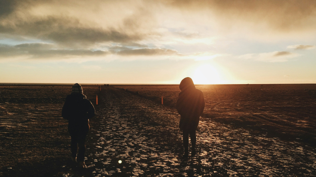 two_people_walking_field_sun_unsplash